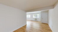 Located at 1000 Oaks Drive in Atlantic Highlands, NJ, this well-appointed single-floor residence offers a clean, modern aesthetic across a thoughtfully organized layout. Gleaming light hardwood floors run throughout the main living areas, lending warmth and continuity to the space.

The living room is open and airy, bathed in natural light from multiple windows that frame views of the surrounding greenery. The seamless flow into the kitchen makes the area feel expansive and connected. The kitchen stands out as a true highlight, featuring soft sage-green shaker cabinetry accented with gold hardware, crisp white countertops, a clean tile backsplash, and a full suite of stainless steel appliances including a range, microwave, dishwasher, and refrigerator.

The spacious bedroom offers ample storage with two double-door closets and large windows that invite natural light and outdoor views. A utility room provides added convenience with in-unit laundry. The bathroom is tastefully updated with a sage-toned vanity with gold accents, a white countertop, and a full tub-shower combination. Neutral white walls throughout create a bright, versatile backdrop. The overall ambiance is clean, contemporary, and move-in ready.