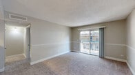 Located at 2320 S Conway Rd in Orlando, FL, this one-bedroom, one-bathroom unit offers a functional and comfortable single-floor layout. The open-concept main living area seamlessly combines the living room, dining room, and kitchen into one cohesive space. The kitchen features granite-style countertops, dark cabinetry, an overhead range hood, and a peninsula that provides a natural divide from the dining and living areas. A pendant light fixture highlights the dining space, while the living room is finished with plush carpeting and neutral-toned walls with a chair-rail accent. Sliding glass doors lead from the living room to a private patio, allowing natural light to fill the space and offering outdoor views. The bedroom is a comfortable size, carpeted, and includes a walk-in closet with built-in shelving, along with a window that brings in additional natural light. The bathroom is outfitted with a full tub-shower combination with white tile surround. Additional features include two closets, a pantry, and two hallways that support efficient circulation throughout the unit. Textured ceilings and updated HVAC vents are consistent throughout, contributing to a well-maintained interior.