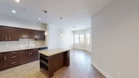This 580-square-foot, one-bedroom, one-bathroom apartment at Los Alisos at Mission Viejo in Mission Viejo, CA features a thoughtfully designed single-floor layout. The open-concept kitchen and living area serves as the heart of the unit, showcasing rich dark wood cabinetry, granite countertops, a subway tile backsplash, a central island with pendant lighting, and a full suite of stainless steel appliances. Warm wood-look flooring extends throughout the main living areas, complemented by neutral walls and abundant natural light from multiple windows and a glass balcony door. The balcony offers elevated views of the landscaped courtyard and surrounding community buildings. The 120-square-foot bedroom features plush carpeting, a large window with exterior views, and direct access to a dedicated closet with built-in shelving. The bathroom is finished with large-format tile flooring, a granite-topped dark wood vanity, a soaking tub and shower combination, and built-in wall shelving. A separate closet provides additional storage. The unit's clean, modern aesthetic and functional layout make it a well-rounded residential space in a well-maintained community setting.