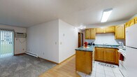 Located at 2551 Villa Dr S in Fargo, ND, this 2-bedroom, 1-bathroom unit offers a practical and comfortable single-floor layout. The open-concept living area seamlessly connects the living room, dining area, and kitchen, creating an efficient and functional space. The kitchen is equipped with warm oak cabinetry, dark granite-style countertops, a breakfast bar peninsula, white appliances including a full-size refrigerator and range, and tile flooring with bright overhead lighting. The living room features a combination of hardwood-style and carpeted flooring, a baseboard heating system, and a sliding glass door that opens to a private patio with outdoor views.

Both bedrooms are carpeted and include vertical blind-covered windows that bring in natural light, along with baseboard heaters for year-round comfort. The primary bedroom is a well-proportioned room with a dedicated closet. A total of four closets throughout the unit provide generous storage options.

The bathroom features tile flooring, a tub-shower combination with white tile surround, a toilet, and a wood-tone vanity with a light countertop. A mirrored sliding closet door in one area adds a sense of depth to the space. Overall, the unit offers a clean, functional layout well-suited for everyday living.