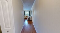 This single-floor, 2-bedroom, 2-bathroom residence offers a thoughtfully designed layout that balances comfort and functionality. Rich hardwood-style flooring flows throughout the main living areas, beginning at a welcoming entry hallway that leads into the heart of the home. The living room is bright and inviting, featuring crown molding, natural light from large windows dressed with grommet curtains, and direct access to an outdoor balcony. Adjacent to the living area, the dining room is bathed in natural light from multiple windows, creating an airy, pleasant atmosphere for meals. The galley-style kitchen is well-equipped with dark espresso cabinetry, granite countertops, stainless steel appliances, track lighting, and a window that brings in additional natural light. Both bedrooms are carpeted for comfort and include ceiling fans, ample natural light, and walk-in closets with built-in rod storage. The primary bedroom is generously sized and offers a peaceful retreat. The bathrooms feature granite-topped vanities with dark wood cabinetry, large mirrors, and a tub-shower combination with tile surround. Three closets throughout the home provide abundant storage. Crown molding and consistent finishes lend a cohesive, polished look to the entire space.