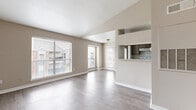 Located at 15570 Bellaire Blvd in Houston, TX, this 2-bedroom, 2-bathroom single-story home offers a practical and well-organized layout. The open-concept living and dining area is bright and airy, featuring light gray wood-look flooring, neutral beige walls, and multiple large windows fitted with blinds that allow abundant natural light to fill the space. A private entry door adds convenience and accessibility directly from the living area.

The kitchen is designed in a galley style with gray cabinetry, tile flooring, a built-in range, refrigerator, and ample counter space. A pass-through window connects the kitchen to the living area, enhancing the open feel of the home.

The generously sized primary bedroom offers two windows with views of the surrounding neighborhood, ceiling fan lighting, and durable wood-look flooring. It includes access to a dedicated walk-in closet outfitted with wire shelving and hanging rods for organized storage. The second bedroom is also well-proportioned, featuring the same consistent flooring and neutral tones throughout.

Both bathrooms are finished with tile flooring, vanity storage, and gray cabinetry. The overall aesthetic of the home is clean, neutral, and move-in ready, offering a comfortable and functional living environment in a well-connected Houston neighborhood.
