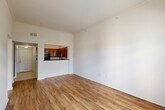 Located at 6765 Corporate Blvd in Baton Rouge, LA, this one-bedroom, one-bathroom unit offers a thoughtfully designed open-concept layout across a single floor. Warm hardwood-style flooring flows throughout the main living areas, complementing the neutral, light-toned walls and creating a cohesive and inviting atmosphere.

The combined living, dining, and kitchen area forms the heart of the unit. The kitchen features rich, warm-toned cabinetry, dark granite countertops, black appliances including a range, microwave, and refrigerator, and a peninsula that opens to the living and dining space — ideal for both cooking and entertaining. The living area benefits from soaring ceilings that enhance the sense of openness, and French doors with a transom window flood the space with natural light while providing access to a private balcony with outdoor views.

The bedroom is a comfortable and well-proportioned retreat, complete with a ceiling fan, a natural light window, and direct access to the full bathroom. The bathroom features dark wood cabinetry, and the bedroom is also connected to two closets, including a spacious walk-in closet with wire shelving for ample storage.

Additional highlights include a dedicated laundry area and a hallway that connects all spaces efficiently, rounding out this well-appointed and functional unit.