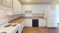 Located at 6967 Collingwood Lane in Woodbury, Minnesota, this single-floor, two-bedroom unit offers a straightforward and functional layout designed for comfortable everyday living. The living area is generously sized, featuring neutral-toned carpet, baseboard heating, and a sliding glass door fitted with vertical blinds that allows natural light to flow in and provides access to an outdoor space. The entryway transitions seamlessly from hard flooring to carpet as it opens into the main living area.

The kitchen is well-appointed with white raised-panel cabinetry extending to the ceiling, offering ample storage throughout. Laminate countertops provide practical workspace, and appliances include a white electric range and a black dishwasher. Wood-look flooring runs through the kitchen, adding warmth to the space.

Both bedrooms are carpeted and feature baseboard heating and windows with blinds, providing natural light and privacy. A hallway connects the bedrooms to the rest of the unit. The bathroom includes a full tub-shower combination with white tile flooring, a toilet, and a built-in vanity area with white cabinetry and a countertop surface conveniently located just outside the bathroom door. The overall aesthetic is clean and neutral throughout.