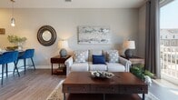 Located at 482–498 Westport St in Norfolk, Virginia, this single-floor residence offers a thoughtfully designed layout with contemporary finishes and a cohesive, neutral color palette throughout. The kitchen is a standout space, featuring stainless steel appliances, white cabinetry, a granite-topped island with bar seating, and warm hardwood-style flooring — all illuminated by pendant lighting that adds a modern touch. The open entryway, accented by a distinctive teal door, leads seamlessly into the main living areas. The living room is inviting and well-proportioned, with hardwood-style floors, soft neutral walls, and ample space for comfortable seating arrangements. The bedrooms are carpeted for warmth and comfort, each offering generous space, natural light through large windows with fitted blinds, and room for substantial furniture pieces. The bathroom is clean and functional, outfitted with a tub-shower combination, a vanity with storage, and hardwood-style flooring that ties back to the rest of the unit. Throughout the residence, recessed lighting, crisp white trim, and a calm, neutral palette create a cohesive and modern living environment that is both practical and visually refined.