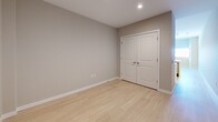 This thoughtfully designed one-bedroom, one-bathroom unit at 6445 America Blvd in Hyattsville, Maryland offers a modern and efficient layout across a single floor. Light wood-style flooring runs throughout, creating a cohesive and bright aesthetic that ties each room together.

The kitchen is a standout feature, equipped with stainless steel appliances including a refrigerator, electric range, and over-the-range microwave. Sleek white cabinetry extends to the ceiling for generous storage, complemented by a light-toned countertop peninsula with an integrated sink — ideal for casual dining or meal prep.

The living room flows naturally from the kitchen, providing an open, functional common area. A bright hallway connects the main living spaces to the private areas of the unit, lined with clean white walls and recessed lighting that maintains the home's airy feel.

The bedroom offers a comfortable, well-proportioned retreat with light walls, wood-style flooring, and a double-door closet providing ample storage. The full bathroom features large-format tile flooring, a white vanity with under-cabinet storage, an illuminated wall mirror, and a tub-shower combination. In-unit laundry adds everyday convenience, rounding out this well-appointed home.