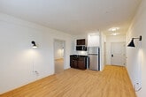 Located at 200 Pinnacle Parkway in Covington, Louisiana, this one-bedroom, one-bathroom unit offers a thoughtfully organized single-floor layout. The entrance opens into a bright, open-concept area that combines the living room, dining space, and kitchen into one cohesive zone. Light wood laminate flooring extends throughout, lending warmth and continuity to the space. The compact kitchen is outfitted with dark-toned cabinetry, a stainless steel refrigerator, a microwave, and a sink — efficiently tucked into a dedicated alcove. Wall-mounted sconce lighting adds a functional design accent to the living area. The generously sized primary bedroom offers a comfortable retreat, featuring a large window with blinds that allows natural light to fill the room, along with a wall-mounted TV bracket and a dedicated closet. The bathroom features light ceramic tile flooring, a granite-topped vanity with an undermount sink, a lighted mirror, and arched interior doors that add a subtle architectural detail. Clean white walls throughout the unit contribute to a bright, neutral atmosphere well-suited for personalizing to any style.