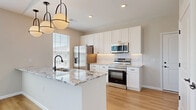 Located at 4985 Warner Rd. in Westerville, OH, this well-designed one-bedroom, one-bathroom residence offers a efficient and modern single-floor layout. The open-concept kitchen and living area serves as the heart of the home, featuring warm luxury vinyl plank flooring, abundant natural light from multiple windows with blinds, and a ceiling fan for added comfort. The kitchen is a standout, equipped with a large granite-topped island with an undermount sink and built-in dishwasher, crisp white shaker cabinetry extending to the ceiling, a textured tile backsplash, and a full suite of stainless steel appliances including a refrigerator, range, and microwave. Stylish pendant globe lights illuminate the island, adding a contemporary touch. The bedroom offers plush carpeting, neutral tones, and a generously sized window that brings in natural light. The full bathroom includes a granite-topped vanity with dark wood cabinetry, a walk-in tiled shower, and hardwood-style flooring. A dedicated closet, laundry area, and utility room round out the practical amenities of this thoughtfully designed residence in Westerville.