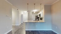 Located at 144 Ponce de Leon Ave NE in Atlanta's vibrant Ponce de Leon corridor, this single-floor residence offers a thoughtfully designed layout with modern finishes throughout. The open-concept living and dining area is anchored by rich, dark hardwood-style flooring and crowned with elegant crown molding, creating a polished and cohesive aesthetic. French doors flood the living space with natural light while providing access to an outdoor area, enhancing the sense of openness. The kitchen is a standout feature, boasting white shaker-style cabinetry, granite countertops, a subway tile backsplash, and a full suite of stainless steel appliances. A peninsula with pendant lighting and an integrated sink adds both functionality and style, making it ideal for entertaining. The bedrooms offer plush wall-to-wall carpeting and ample natural light, with one bedroom featuring a walk-in closet for added storage convenience. The bathroom is finished with clean white tile surrounding a full soaking tub and shower combination, complemented by wood-style flooring. Neutral, warm-toned walls throughout the residence create a calm and welcoming ambiance, making this Atlanta home a comfortable and contemporary retreat.