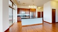Located at 3115 Lilly Rd in Brookfield, WI, this well-appointed 2-bedroom, 3-bathroom single-floor residence offers a thoughtfully designed layout with quality finishes throughout. The open-concept living area seamlessly connects the living room, dining space, and kitchen, all anchored by warm hardwood flooring and flooded with natural light through expansive multi-pane windows. The kitchen is a standout feature, boasting rich wood cabinetry, dark granite countertops, stainless steel appliances including a range, microwave, and refrigerator, and a large central island with pendant lighting above. Two private balconies extend the living space outdoors, accessible via sliding glass doors. The generously sized primary bedroom offers plush carpeting, a large window with outdoor views, and access to an impressive walk-in closet fitted with extensive wire shelving and hanging systems. The second bedroom is equally well-lit with carpeting and a sizable window. Three full bathrooms include clean, modern fixtures, warm wood cabinetry, and a glass-enclosed walk-in shower with built-in shelving. A dedicated laundry area and four total closets provide abundant storage. The hallway and entrance tie the layout together cohesively, completing this comfortable and functional Brookfield residence.