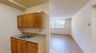 Located at 1021 Asylum Ave in Hartford, CT, this two-bedroom, one-bathroom unit offers a practical and efficiently designed single-floor layout. Light-toned tile flooring runs consistently throughout the space, lending a clean, cohesive look to every room.

The kitchen is positioned at the entry of the unit and features warm wood cabinetry, a granite-patterned countertop, and a stainless steel sink. It opens directly into the living area, which benefits from a large window that brings in natural light and outdoor views of the surrounding neighborhood.

The spacious primary bedroom is notably generous in size, offering ample room for furnishings, and is equipped with baseboard heating and a large closet with louvered bifold doors. The second bedroom is similarly bright and comfortable, also featuring a closet with bifold doors and a window overlooking the exterior. Both bedrooms share the clean, consistent tile flooring found throughout the unit.

The full bathroom includes a tub-shower combination with white tile surround, a wood-vanity with a white sink, and a mirrored medicine cabinet above. Three closets distributed throughout the unit provide convenient and practical storage solutions. Baseboard heating is present in multiple rooms, ensuring consistent warmth throughout the colder months.