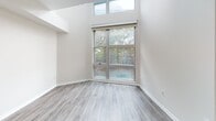 Located in the heart of Los Angeles, this two-story residence at 138 N Beaudry Ave offers a thoughtfully designed layout with modern finishes throughout. The main level features an open-concept living and dining area with light wood-style flooring that flows seamlessly toward a well-appointed kitchen. The kitchen stands out with bold navy cabinetry, brushed gold hardware, quartz countertops, a marble-look tile backsplash, and stainless steel appliances including a gas range and built-in microwave. A peninsula separates the kitchen from the living area, enhancing the open feel of the space. A clean, minimalist bathroom on this level features wood-tone flooring, a white vanity, and a large mirror. The upper level is characterized by soaring ceilings and oversized windows that frame views of surrounding greenery, filling the space with natural light. Additional windows on the upper landing overlook the cityscape. Bedrooms on this level are generously proportioned, each offering closets with wire shelving for organized storage. A second bathroom upstairs echoes the refined design palette with a navy vanity, gold fixtures, and a backlit mirror. A staircase with wood treads connects both levels, contributing to the home's airy, multi-level character.