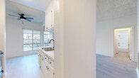Located at 1450 Midvale Ave in the desirable Westwood neighborhood of Los Angeles, this one-bedroom, one-bathroom unit offers a thoughtfully organized layout spread across a single floor. Light-toned hardwood flooring flows throughout the space, complementing a clean, neutral color palette that enhances the bright and airy atmosphere.

The living room is a standout area, featuring a white brick fireplace, a textured ceiling, and a wall of large windows that flood the room with natural light while offering leafy outdoor views. A convenient pass-through window with a built-in counter connects the living area directly to the kitchen, improving both function and openness.

The galley-style kitchen is well-appointed with white cabinetry, a tile backsplash, stainless steel appliances including a range and refrigerator, and a matte black faucet over a double-basin sink — all set atop light wood flooring.

The bedroom is a comfortable, well-proportioned retreat featuring a sliding mirrored closet with built-in shelving, a window with natural light, and direct access to the hallway. The bathroom is clean and functional, outfitted with a full tiled tub-shower combination, wood-look flooring, and crisp white finishes throughout.
