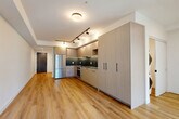 This well-designed three-bedroom, two-bathroom unit in Squamish, BC offers a thoughtfully arranged single-floor layout that maximizes functionality. Light-toned hardwood flooring runs throughout, complementing the bright, neutral palette of white walls and modern trim.

The kitchen is a standout feature, showcasing flat-panel light wood cabinetry extending to the ceiling, dark tile backsplash, dark countertops, stainless steel appliances including a built-in oven and French door refrigerator, and a undermount sink — all illuminated by track lighting overhead. The adjacent living area benefits from generous natural light and access to an outdoor space framed by sliding glass doors, offering views of the surrounding Squamish mountain landscape.

The bedrooms are bright and functional, with large windows capturing mountain and neighbourhood views. Baseboard heating is featured throughout, and at least one bedroom includes a sliding-door closet. The primary bedroom is efficiently sized, suited for essential furnishings.

Both bathrooms are finished in a contemporary style with square tile surrounds, matte black fixtures, and wood-accented vanities. One bathroom features a soaking tub with overhead rain shower, while the second includes a glass-enclosed walk-in shower.
