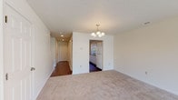 Located at 3701 Upper Mount Vernon Rd in Evansville, Indiana, this two-floor residential space offers a functional and comfortable layout throughout. The living area is finished with plush neutral carpeting and anchored by an elegant chandelier, creating a warm and inviting atmosphere. A hallway with hardwood-style flooring connects the main living spaces, adding a contrasting touch of warmth underfoot.

The kitchen is well-equipped and features white cabinetry with ample storage, dark laminate countertops, a double-basin sink, a dishwasher, a range with overhead microwave, and a full-size refrigerator. Hardwood-style flooring runs throughout the kitchen, and a pass-through view connects it to a naturally lit area beyond.

The bedrooms are carpeted and each include ceiling fans with light fixtures and windows fitted with blinds that allow natural light. One bedroom features a closet with built-in shelving, while another adjoins a bathroom, providing added convenience. The full bathroom is clean and functional, offering a tub/shower combination, vanity with storage, and hardwood-style flooring.

A carpeted hallway links the bedrooms and connects the upper level, providing a smooth flow between spaces. Throughout, the interior is finished in neutral tones, creating a clean and move-in-ready environment.