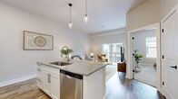 Located in Nashville's vibrant Wedgewood neighborhood, this thoughtfully designed one-bedroom, one-bathroom residence offers a cohesive open-concept layout that maximizes its efficient footprint. The combined kitchen and living area serves as the heart of the home, anchored by a granite-topped kitchen island with pendant lighting and seating for two — ideal for casual dining or entertaining. White shaker cabinetry, stainless steel appliances, and warm wood-look flooring give the kitchen a clean, contemporary feel. The living area flows naturally toward a sliding glass door that opens to a private balcony, filling the space with natural light and outdoor views. The bedroom is a calm retreat, featuring plush carpet, a generous window, and a ceiling fan. It is complemented by a dedicated closet for storage. The bathroom continues the home's refined aesthetic with granite countertops, white cabinetry, and wood-look flooring. Neutral tones and consistent finishes throughout create a harmonious and inviting ambiance, making this Nashville residence a functional yet stylish place to call home.