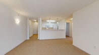 Located at 6191 WIS-100 N in Hales Corners, Wisconsin, this single-floor residence offers a well-organized and functional layout throughout. The open living area is a standout feature, characterized by neutral carpeting, crisp white walls, and elegant decorative columns that lend architectural interest to the space. A sliding glass door fills the living room with natural light and provides access to the outdoors. The kitchen is designed for practicality, featuring white cabinetry with gold hardware, a full suite of white appliances including a refrigerator, electric range, built-in microwave, and dishwasher, as well as a peninsula with a pass-through opening to the main living area. Light hardwood-style flooring adds warmth to the kitchen. The bedrooms are generously sized with plush carpeting, large windows dressed with blinds, and ceiling fans for added comfort. One bedroom benefits from dual windows, enhancing its airy feel. The bathrooms are finished with light tile flooring, wide vanities, large mirrors, and a glass-enclosed shower. Grab bars are present in one bathroom, offering added accessibility. Throughout the residence, the clean, neutral palette and consistent finishes create a bright, cohesive ambiance.