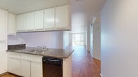 Located at 808 Fourth Avenue in San Diego's vibrant downtown district, this one-bedroom, one-bathroom residence offers a well-organized, single-level layout with consistent hardwood-style flooring throughout. The open-concept design seamlessly connects the kitchen, dining, and living areas into one cohesive space.

The kitchen is equipped with white cabinetry, granite-style countertops, a peninsula with a double stainless steel sink, a dishwasher, a range, a microwave, and a full-size refrigerator. The peninsula serves as a natural divider between the kitchen and the combined dining and living area.

The living room is bright and airy, featuring a large sliding glass door fitted with vertical blinds that opens to an outdoor view of the surrounding San Diego cityscape and greenery, filling the space with natural light.

The bedroom is a comfortable, well-proportioned room with its own sliding glass door providing additional natural light and outdoor views. A dedicated hallway connects the bedroom to the full bathroom and features mirrored closet doors on both sides, offering generous storage. The bathroom includes a granite-topped vanity with white cabinetry, a large mirror, and a full tub-shower combination. Three total closets provide ample storage throughout the residence.