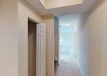Located at 4495 Emerald Vista in Lake Worth, Florida, this two-story home offers a functional and well-organized layout across both levels. The main floor features light ceramic tile flooring throughout, contributing to a clean, cohesive look. The kitchen is equipped with white cabinetry, dark countertops, a central island with additional counter space, and white appliances including a refrigerator. A convenient half bathroom on the main level includes a pedestal sink, toilet, and a window that allows natural light to filter in. Also on the main floor is a dedicated laundry room housing a full-size washer and dryer with additional shelving above. A staircase with white railings connects the two floors. Upstairs, the bedrooms feature warm carpeting and generous closet space, including a large walk-in closet with wire shelving on multiple walls for ample storage. A full bathroom on the upper level includes a glass-enclosed shower stall, vanity with white cabinetry, and tile flooring. The hallway on the upper level also features a closet with hanging rod. Throughout the home, neutral warm tones on the walls and consistent light flooring create a bright, welcoming atmosphere well-suited to Florida living.