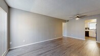 Located at 301 Seacrest Dr in Largo, FL, this single-story 1-bedroom, 1-bathroom unit offers a well-organized layout across a compact yet functional floor plan. The living room greets you with warm wood-look vinyl flooring, neutral gray walls, a textured ceiling, and a ceiling fan. A large vertical-blind window allows natural light to fill the space, creating a bright and welcoming atmosphere.

The kitchen is thoughtfully equipped with white raised-panel cabinetry, white countertops, a dark tile backsplash, and black appliances including a range, dishwasher, and refrigerator. A window above the sink provides additional natural light. Notably, a stacked washer and dryer unit is conveniently located within the kitchen area, adding in-unit laundry functionality.

The spacious primary bedroom features the same wood-look flooring, a textured ceiling, a window for natural light, and access to a dedicated closet with sliding doors. A hallway connects the bedroom to the rest of the unit.

The bathroom includes a full tub/shower combo with chrome fixtures, a toilet, and diagonal-set tile flooring in a neutral tone. The overall design is clean and consistent, with a neutral color palette throughout that lends itself well to a variety of furnishing styles.