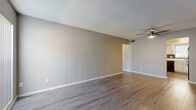 Located at 301 Seacrest Dr in Largo, FL, this single-story 1-bedroom, 1-bathroom unit offers a well-organized layout across a compact yet functional floor plan. The living room greets you with warm wood-look vinyl flooring, neutral gray walls, a textured ceiling, and a ceiling fan. A large vertical-blind window allows natural light to fill the space, creating a bright and welcoming atmosphere.

The kitchen is thoughtfully equipped with white raised-panel cabinetry, white countertops, a dark tile backsplash, and black appliances including a range, dishwasher, and refrigerator. A window above the sink provides additional natural light. Notably, a stacked washer and dryer unit is conveniently located within the kitchen area, adding in-unit laundry functionality.

The spacious primary bedroom features the same wood-look flooring, a textured ceiling, a window for natural light, and access to a dedicated closet with sliding doors. A hallway connects the bedroom to the rest of the unit.

The bathroom includes a full tub/shower combo with chrome fixtures, a toilet, and diagonal-set tile flooring in a neutral tone. The overall design is clean and consistent, with a neutral color palette throughout that lends itself well to a variety of furnishing styles.