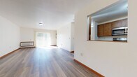 Located at 3148 Muir Field Rd in Madison, Wisconsin, this single-floor residence offers a well-designed layout that balances open living spaces with functional room arrangements. The expansive living area is finished with wide-plank hardwood-style flooring that runs throughout, complemented by crisp white walls and warm wood baseboards that create a clean, inviting atmosphere. A large sliding glass door floods the living space with natural light and provides outdoor access, while a pass-through window connects the living area seamlessly to the kitchen.

The kitchen is outfitted with warm-toned wood cabinetry, granite-style countertops, and stainless steel appliances including an electric range and over-the-range microwave, offering both style and practicality. The layout provides ample counter and storage space for everyday use.

The unit includes two bathrooms: one features a walk-in shower with a built-in grab bar and a wood-vanity with granite countertop, while the second is equipped with a soaking tub and similar vanity finishes. Both bathrooms are finished with durable wood-look flooring. Additional spaces visible in the dollhouse view suggest multiple bedrooms and well-proportioned closet storage. A ceiling fan in the hallway area adds comfort throughout this thoughtfully appointed single-level home.