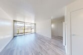 Located at 1405 Marshall Street in Redwood City, CA, this well-appointed unit offers a thoughtfully designed single-floor layout that maximizes functionality and natural light. The combined kitchen and living area serves as the heart of the space, where light-toned hardwood flooring flows seamlessly throughout, complementing the bright, neutral walls and textured ceilings. Floor-to-ceiling sliding glass doors bathe the living area in abundant natural light and open to an outdoor balcony, providing views of the surrounding Redwood City neighborhood.

The kitchen is outfitted with white cabinetry, granite countertops, a tile backsplash in warm earth tones, and black appliances including a refrigerator, range, and over-the-range microwave. A peninsula counter provides additional workspace and casual dining potential.

The bathroom features a clean, functional design with a white vanity, granite-style countertop, mirrored medicine cabinet, and a shower-tub combination. A dedicated closet with built-in shelving and a hanging rod offers practical storage. The overall ambiance of the unit is light, clean, and modern, making it a comfortable and efficient living space in the heart of the San Francisco Bay Area.