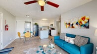 Located at 3631 Callaghan Road in San Antonio, Texas, this 2-bedroom, 1-bathroom single-story unit offers a functional and well-organized layout across a compact, efficient footprint. The open-concept living, dining, and kitchen area forms the heart of the home, featuring light wood-look flooring, a textured ceiling, and a ceiling fan that enhances airflow and comfort. The living room receives natural light through a sliding glass door that opens onto a private patio, offering pleasant outdoor views. The kitchen is well-appointed with white cabinetry, granite-style countertops, black appliances including a range and refrigerator, and a central island that provides additional prep space and storage. A stacked washer and dryer unit is conveniently integrated near the kitchen area. The dining space sits adjacent to the kitchen, creating a cohesive entertaining area. Both bedrooms feature ceiling fans, light wood-look flooring, natural light from windows with blinds, and closet storage. The primary bedroom offers a comfortable, well-proportioned space. The bathroom includes a tub-shower combination with tile surround and wood-look flooring. A hallway connects the private areas of the home seamlessly.