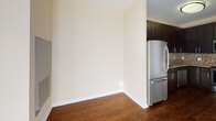 Located at 11215 Georgia Ave in Silver Spring, Maryland, this single-floor residence offers a well-designed layout with contemporary finishes throughout. Rich hardwood flooring flows seamlessly across the main living areas, creating a warm and cohesive aesthetic.

The kitchen is a standout feature, outfitted with dark espresso cabinetry that extends to the ceiling for ample storage, granite-style countertops, and a full suite of stainless steel appliances including a refrigerator, range, built-in microwave, and dishwasher. A mosaic tile backsplash adds a refined decorative touch that complements the overall design.

The open living area is bathed in natural light, courtesy of large floor-to-ceiling windows and a sliding glass door that leads to a private balcony, offering views of the surrounding building exterior. The neutral wall tones enhance the brightness of the space.

The bathroom is finished with light tile flooring, a vanity featuring dark cabinetry with granite countertops, an overhead mirror, and standard fixtures. A keypad-equipped entry door adds a modern, secure touch to the unit's entryway. Overall, the space presents a clean, modern aesthetic with practical, well-appointed details throughout.