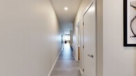 Located at 500 E 8th Street in Kansas City, Missouri, this well-appointed one-bedroom, two-bathroom unit offers a thoughtfully designed layout with a clean, modern aesthetic throughout. The open-concept kitchen and living area serve as the heart of the home, featuring a fully equipped kitchen with stainless steel appliances, two-toned cabinetry combining white upper cabinets with warm wood lower cabinets, a classic white subway tile backsplash, and light countertops. A dining area with a wood high-top table completes the space. The living room is highlighted by expansive floor-to-ceiling windows that frame sweeping city views, flooding the space with natural light and creating an airy, elevated atmosphere. The generously sized primary bedroom offers a serene retreat with soft neutral tones, plush carpeting, and a built-in closet. Both bathrooms are finished with contemporary fixtures, including a sleek walk-in shower enclosed in frameless glass with floor-to-ceiling white tile, and a bathroom featuring warm wood vanity cabinetry with a white basin. Light vinyl flooring runs throughout the main living areas, tying the space together with a cohesive, modern feel.