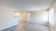 Located at 4125 Lacy Ln in Colorado Springs, CO, this 2-bedroom, 2-bathroom single-floor home offers a functional and comfortable layout. The living room serves as a welcoming focal point, featuring wood-look laminate flooring, neutral-toned walls, a textured ceiling, and a classic fireplace with a dark surround — ideal for Colorado's cooler seasons. Natural light filters in through slatted window blinds, adding brightness to the space. A ceiling fan overhead enhances comfort in the adjoining dining area, which connects seamlessly to the kitchen via a half-wall pass-through. The kitchen is well-appointed with white shaker-style cabinetry, dark granite countertops, a stainless steel sink, and black appliances, all complemented by matching wood-look flooring. Both bedrooms are carpeted for comfort and receive natural light through windows. The spacious primary bedroom offers ample room for furnishings. Each bathroom features a tiled tub-shower combination with chrome fixtures in a clean, neutral palette. A hallway connects the private areas of the home, with a closet providing additional storage. The overall aesthetic is clean, neutral, and move-in ready.