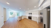Located at 23905 Van Ry Blvd in Mountlake Terrace, WA, this well-appointed residence offers five bedrooms and two bathrooms across a single floor. The open-concept kitchen is a standout feature, showcasing sleek white cabinetry, stainless steel appliances including a range, microwave, and dishwasher, light quartz countertops, and a peninsula with a sink. Recessed lighting illuminates the space, which flows seamlessly toward a sliding glass door that invites natural light from the outdoors. The kitchen and common areas are finished with warm hardwood-style flooring, lending a clean, modern aesthetic throughout. The bedrooms offer a mix of finishes — several feature plush carpeting, ceiling fans, and windows that bring in natural light and outdoor views. The primary bedroom provides a generous, comfortable retreat. Both bathrooms are clean and functional, each equipped with a full tub-shower combination and chrome fixtures. A dedicated closet and hallway provide practical storage and connectivity between rooms. The bright, neutral color palette of white walls and light flooring throughout creates a fresh, move-in-ready atmosphere suitable for a variety of living arrangements.