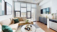 This 620 square foot apartment showcases a modern and efficient design, maximizing space in its 3-bedroom, 1-bathroom layout. The open-concept living area serves as the heart of the home, featuring a comfortable L-shaped sofa, contemporary artwork, and large windows that flood the space with natural light and offer city views. The kitchen boasts sleek white cabinetry, stainless steel appliances, and a convenient breakfast bar, seamlessly integrating with the dining area.

The bedrooms, including a 110 square foot primary bedroom, are thoughtfully designed with plush bedding, stylish decor, and ample storage solutions. Each room maintains a cohesive aesthetic with neutral tones accented by pops of color in pillows and artwork. The bathroom, while compact, features modern fixtures and a clean, minimalist design.

Throughout the apartment, the decor strikes a balance between functionality and style, with carefully curated pieces that add character without overwhelming the space. Exposed concrete ceilings and wooden flooring lend an industrial-chic vibe, while strategically placed lighting fixtures create a warm ambiance. Despite its modest size, this apartment offers a comfortable and contemporary living experience in an urban setting.