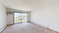 Located at 9850 Excelsior Blvd in Hopkins, Minnesota, this single-floor, 2-bedroom, 1-bathroom residence offers a well-organized layout designed for comfortable everyday living. The living room serves as the heart of the home, featuring plush carpeting, baseboard heating, a wall-mounted air conditioning unit, and a large sliding glass door framed by vertical blinds that fills the space with natural light and provides outdoor views. A dedicated entrance with a solid wood door offers a welcoming entry point. The galley-style kitchen is efficiently designed with rich wood cabinetry, granite-look countertops, stainless steel appliances including a refrigerator, electric range, and microwave, plus a double sink — all complemented by tile flooring and a ceiling fan in the adjacent dining area. Both bedrooms are carpeted and bright, with the generously sized primary bedroom offering notable space. Wood panel doors are consistent throughout, adding a warm, cohesive aesthetic. The unit is exceptionally well-equipped with five closets, providing abundant storage throughout. The full bathroom features tile flooring, a wood vanity, and a tub-shower combination.