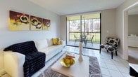 Located at Aventura Harbor, this well-appointed single-floor residence offers a thoughtfully designed layout with a warm, contemporary aesthetic throughout. The living room serves as the heart of the home, finished with large white tile flooring and floor-to-ceiling sliding glass doors that open onto a private balcony, filling the space with abundant natural light and views of lush tropical palm trees and manicured grounds. The kitchen is efficiently laid out in a U-shape, featuring crisp white cabinetry, granite countertops, a tile floor, and a full suite of appliances including a dishwasher and electric range. A dedicated dining area with tile flooring and a chandelier connects the kitchen to the living space. The primary bedroom is spacious and carpeted, with soft neutral tones, a sliding glass door providing direct balcony access, and a connected second bedroom visible through an interior doorway. A versatile secondary room offers built-in shelving and a window, functioning well as a home office or additional bedroom. The bathroom is clean and functional, featuring tile flooring, a granite-topped vanity with undermount sink, and a full soaking tub with a shower curtain. A bright hallway connects all rooms seamlessly, reinforcing the open, cohesive flow of the entire residence.