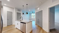 Located at 34 Ramsey Branch Rd in Freeport, FL, this well-appointed single-floor unit offers a thoughtfully designed layout with one bedroom, one bathroom, and a dedicated laundry area. The open-concept kitchen and living room serve as the heart of the home, centered around a granite-topped island with an undermount sink and striking matte black pendant lighting. White shaker cabinetry lines the kitchen walls, complemented by a full suite of stainless steel appliances including a French door refrigerator, range, microwave, and dishwasher, all set against a herringbone tile backsplash. Light hardwood-style flooring flows throughout the main living areas, adding warmth and continuity. The living room benefits from natural light via a front-facing window and is equipped with a ceiling fan. The generously sized bedroom features plush carpeting, a ceiling fan, a natural light window, and ample closet space — with three closets total found throughout the unit. The clean, neutral-toned bathroom offers a granite vanity, white shaker cabinetry, and a full tub-shower combination with vertically stacked white tile surround. A dedicated laundry space adds everyday convenience to this modern, move-in-ready residence.