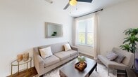 Located at 230 Flagship Way in Knoxville, Tennessee, this single-floor, 2-bedroom, 2-bathroom unit offers a clean, modern aesthetic with consistent finishes throughout. Light-toned hardwood floors run seamlessly across all rooms, complementing the crisp white walls and creating a bright, cohesive atmosphere.

The open-concept kitchen and living area serves as the heart of the unit. The kitchen features gray shaker-style cabinetry, granite countertops, stainless steel appliances — including a range, microwave, and dishwasher — and a central island with seating for two, illuminated by a pair of bold pendant lights. The adjoining living room benefits from large windows dressed with sheer curtains and blinds that frame views of surrounding greenery, while a ceiling fan adds comfort overhead.

The primary bedroom is a comfortable, well-proportioned retreat with large windows offering outdoor views, a ceiling fan, and access to a walk-in closet with built-in shelving. The second bedroom similarly features a window with natural views, a built-in desk area, and dedicated storage. Both bathrooms maintain the granite countertop theme with gray vanity cabinetry. The overall ambiance is light, neutral, and functional, making efficient use of the available footprint.