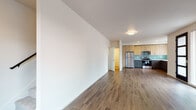 Located at 970 W 17th Ave in Junction City, Oregon, this two-story unit showcases a clean, contemporary design with thoughtfully selected finishes throughout. The main living area is open and generously proportioned, featuring warm wood-tone laminate flooring, neutral walls, and a door that opens to a private balcony, allowing natural light to fill the space. A wall-mounted mini-split system provides efficient climate control.

The kitchen is a standout feature, designed with a two-tone cabinet scheme pairing light natural wood uppers with dark lower cabinets. White countertops, a soft aqua glass tile backsplash, and stainless steel appliances—including a refrigerator, range, microwave, and dishwasher—complete the modern aesthetic. A window above the sink provides additional natural light.

The bathrooms are finished with dark vanity cabinetry, white countertops, and light tile flooring, offering a clean and functional design. Upstairs, carpeted bedrooms with corner windows provide a quiet retreat with ample natural light. A dedicated utility closet houses the water heater. The two-floor layout offers a practical separation between living and sleeping areas.