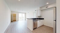 Located in Los Angeles, this thoughtfully designed unit offers three bedrooms and three bathrooms across a well-utilized single-floor layout. The open-concept kitchen and living area serves as the heart of the home, featuring a peninsula with dark countertops, crisp white cabinetry with brushed nickel hardware, stainless steel appliances including a dishwasher, electric range, and built-in microwave, all complemented by light wood-look flooring that flows seamlessly throughout. The living area is bathed in natural light from a sliding glass door that opens to a private balcony with outdoor views of the surrounding neighborhood. Each of the three bedrooms offers a clean, neutral palette with recessed lighting and easy access to dedicated bathrooms. The spacious primary bedroom includes an en-suite bath featuring a soaking tub with tiled surround. Additional bedrooms are well-proportioned, with one featuring a window framing palm tree views. Closets with built-in rods provide practical storage. The bathrooms are finished in a clean, modern style consistent with the rest of the unit. A connecting hallway ties all spaces together efficiently, creating a cohesive and functional living environment ideal for shared or family occupancy.