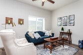 Located at 745 W Fine Dr in South Salt Lake, UT, this 2-bedroom, 2-bathroom residence offers a functional and cohesive single-floor layout designed for comfortable everyday living. The kitchen is a standout feature, showcasing rich dark cabinetry, granite countertops, black appliances, and wood-style flooring that extends throughout the main living areas. A breakfast bar with seating connects the kitchen to the adjacent dining area, which benefits from generous natural light streaming through a sliding glass door. The living room is bright and welcoming, featuring a ceiling fan and a large window that fills the space with daylight. The primary bedroom offers a comfortable, carpeted retreat with ample natural light, while the second bedroom is versatile and well-lit, with large windows making it well-suited as a home office or guest room. Both bathrooms are finished with granite-topped dark vanities and wood-style flooring; one includes a full soaking tub with shower. A dedicated in-unit laundry room with wire shelving adds practical convenience. Neutral wall tones and consistent finishes throughout create a clean, cohesive aesthetic across the entire residence.