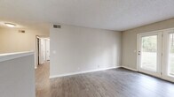 Located at 118 E Kingwood Dr in Murfreesboro, Tennessee, this single-floor, two-bedroom, two-bathroom residence offers a practical and well-appointed layout. The living room is a bright, open space finished with durable wood-look flooring and neutral-toned walls beneath a textured ceiling. A standout feature is the set of white-framed French doors that flood the room with natural light and provide views of the surrounding greenery outdoors. The galley-style kitchen is efficiently designed, featuring white shaker cabinetry, marble-look countertops, a stainless steel sink, and black and stainless steel appliances including a refrigerator, electric range, and dishwasher — all set over light wood-look flooring. A hallway connects the main living areas to the two bedrooms, both of which are carpeted and receive natural light through windows. The generously sized primary bedroom offers direct access to one of the two bathrooms, which is finished with a white vanity and marble-look countertop. The second bathroom mirrors this clean, modern aesthetic. Throughout the residence, consistent neutral tones, white trim, and updated finishes create a cohesive and move-in-ready atmosphere.
