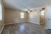 Located at 1011 S James St. in Jacksonville, Arkansas, this single-story 2-bedroom, 2-bathroom unit offers a practical and well-organized layout. The living room serves as the welcoming entry point, featuring light-toned vinyl plank flooring, a ceiling fan, a textured ceiling, and a window that allows natural light to fill the space. The galley-style kitchen is efficiently designed with white cabinetry, a double-basin sink, laminate countertops, and white appliances including an electric range and refrigerator, all set atop matching vinyl plank flooring. Both bedrooms are carpeted for comfort and equipped with ceiling fans. The primary bedroom offers a notably generous footprint for the overall unit size, while the second bedroom includes a closet and a window with natural light. Each room features neutral beige walls that contribute to a clean, cohesive aesthetic throughout. The two bathrooms are functional and tidy — one features a vanity with under-cabinet storage and a lighted mirror, while the other includes a full tub-shower combination with crisp white surround panels. A connecting hallway links the bedrooms and bathrooms, providing an efficient flow through the home. Vinyl plank flooring is consistent across the main living areas, adding durability and a modern touch.