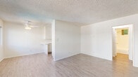 Located in Northridge, Los Angeles, this one-bedroom, one-bathroom unit offers a practical and well-organized single-floor layout. The combined kitchen and living area forms the heart of the unit, filled with natural light streaming through dual windows. Light wood-style flooring runs throughout, complementing the clean white walls and textured ceilings. A wall-mounted AC unit keeps the living space comfortable year-round.

The kitchen is efficiently designed with white cabinetry, marble-look countertops, a double-basin sink, a dishwasher, and an electric range — providing ample functionality in a compact footprint.

The bedroom offers a cozy atmosphere with plush carpeting, a ceiling fan with integrated lighting, a sliding-door closet for storage, and a window overlooking lush greenery, bringing a touch of nature indoors.

The bathroom is clean and straightforward, featuring a full tub-shower combo with white surround, a toilet, and a vanity with marble-look countertops that echo the kitchen's finishes. A frosted window provides ventilation and privacy.

Throughout the unit, the light color palette and consistent finishes create a cohesive, airy ambiance well-suited to comfortable everyday living in the San Fernando Valley.
