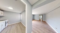 Located at 105 Roney Ln in Syracuse, NY, this two-bedroom, one-bathroom unit offers a compact and efficiently laid out single-floor design. Throughout the space, light hardwood flooring and cool blue-gray walls create a calm, cohesive aesthetic that flows from room to room.

The spacious primary bedroom is a standout feature of the unit, offering generous proportions, a built-in closet, and a cast-iron radiator beneath a window that allows natural light to filter in. The second bedroom mirrors a similar character, with its own radiator and window providing both warmth and daylight. Both bedrooms feature clean white trim that complements the soft wall tones.

The kitchen is functional and neatly arranged, featuring a white gas range with overhead ventilation, light hardwood flooring, and a window fitted with blinds that brings in additional natural light. Its understated design keeps the space practical and easy to maintain.

The bathroom is bright and clean, centered around a full bathtub with a tiled surround and a dedicated window with blinds, enhancing ventilation and natural light. A hallway connects the rooms, providing a logical and efficient flow throughout the unit.

Overall, this unit presents a consistent, move-in-ready aesthetic with classic heating elements, natural light in every room, and durable flooring throughout.