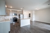 Located at 1200 Felix Way in Westampton, NJ, this single-floor residence offers a thoughtfully designed layout with two bedrooms, two bathrooms, and a seamless flow between living spaces. The open-concept kitchen and living area serves as the heart of the home, featuring gray shaker-style cabinetry, white quartz countertops, stainless steel appliances, a central island, and wood-look luxury vinyl plank flooring that extends throughout the main living areas. A sliding glass door floods the living room with natural light and provides access to the outdoors. The spacious primary bedroom features plush carpeting and a generous walk-in closet with wire shelving. The en-suite primary bathroom is elegantly finished with marble-look tile flooring, a double-sink vanity with gray cabinetry, and a glass-enclosed walk-in shower. The second bedroom also offers soft carpeting and large windows with outdoor views. The second full bathroom includes marble-look tile floors, a gray vanity, and a tub-shower combination. A hallway connects the rooms efficiently, and the clean, neutral palette throughout creates a bright, modern ambiance well-suited for comfortable everyday living.