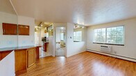 This 480 square foot apartment in Boulder, Colorado offers a well-designed living space within a compact footprint. The single-story layout includes two bedrooms, one bathroom, and an open-concept kitchen and living area. Hardwood flooring throughout most of the space adds warmth and durability, while large windows in the bedrooms and living area provide ample natural light.

The kitchen features wooden cabinetry, a countertop bar for casual dining, and opens directly to the living room, creating an efficient and sociable layout. The bathroom showcases a modern aesthetic with a glass-enclosed shower and neutral tiling. In the bedrooms, carpeting adds comfort underfoot, and one room includes a built-in wooden desk, ideal for a home office setup.

Track lighting and window-mounted air conditioning units offer practical amenities. The apartment's design makes clever use of space, with features like a large mirror in one room to create the illusion of more space. The entry area includes arched windows above the door, adding architectural interest. Overall, this apartment combines functionality with modern touches, offering a cozy yet stylish living environment in a desirable Boulder location.