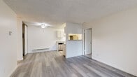 This single-floor, 2-bedroom, 2-bathroom residence in Fremont, CA (94538) offers a functional and well-organized layout designed to maximize its available footprint. The open-concept living and dining area serves as the central hub of the unit, featuring light gray wood-look laminate flooring, a textured ceiling, a ceiling fan, and a wall-mounted heater. A half-wall partition separates the living space from the kitchen, enhancing the sense of openness while maintaining distinct zones.

The galley-style kitchen is efficiently designed with ample white cabinetry, light gray countertops, a stainless steel sink, and appliances including a refrigerator, electric range, and dishwasher. Light flooring runs throughout the kitchen, complementing the clean, neutral palette.

Both bedrooms offer plush carpeting, baseboard heating, and dedicated closets. The primary bedroom receives natural light through a window with vertical blinds. Each of the two bathrooms is equipped with a full tub-shower combination with chrome fixtures, maintaining a clean, utilitarian aesthetic consistent throughout the unit. A dedicated entryway with a paneled front door and baseboard heater provides a practical transition into the living space.