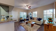 Located at 2024 Quail Creek Dr in Laredo, Texas, this single-story unit offers a thoughtfully designed layout with a warm, inviting atmosphere throughout. The living room serves as the heart of the home, featuring rich hardwood-style flooring, a ceiling fan, a textured ceiling, and multiple windows fitted with horizontal blinds that draw in generous natural light and offer views of the surrounding greenery. The space accommodates both a comfortable seating arrangement and a cozy reading nook near the entry door.

Adjacent to the living area, a dedicated dining space provides an intimate setting with warm neutral walls and framed wall art, ideal for everyday meals or entertaining. The galley-style kitchen is equipped with dark cabinetry, granite-style countertops, black appliances, and ample cabinet storage on both sides, offering a practical and efficient workspace.

The bedrooms are carpeted and well-sized, each benefiting from natural light through sizable windows. One bedroom includes direct access to a full bathroom with a shower and built-in shelving. The bathrooms feature dark wood vanities with granite-style countertops, hardwood-style flooring, and well-lit mirrors, delivering a clean and functional design. Overall, the unit presents a cohesive, comfortable living environment with consistent finishes throughout.