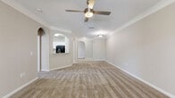 Located in Largo, FL, this single-story home offers four bedrooms, three bathrooms, and a thoughtfully arranged floor plan. The kitchen is a standout feature, showcasing white shaker-style cabinetry, granite countertops, a classic tile backsplash, and black appliances including a dishwasher, electric range, microwave, and refrigerator. Light wood-style flooring runs through the kitchen, which opens to the rest of the home through an elegant arched passageway. The living room is generously sized with plush carpeting, crown molding, and a ceiling fan, and features sliding glass doors that open to an outdoor balcony with a lush tree-lined view. The spacious primary bedroom includes its own bathroom with a walk-in closet offering built-in shelving. The additional bedrooms are carpeted and bright, each with windows allowing natural light and access to ceiling fans. The bathrooms are clean and functional, with one featuring a full tub-shower combination and wood-look tile flooring. A hallway connects the rooms efficiently, and three closets throughout the home provide excellent storage. The neutral color palette and consistent finishes create a cohesive, move-in ready atmosphere throughout.