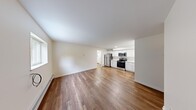Located at 2001 Huron Parkway in Ann Arbor, Michigan, this well-appointed one-bedroom, one-bathroom unit offers a practical and comfortable single-floor layout. Warm hardwood-style flooring runs throughout, tying each room together with a consistent, clean aesthetic.

The open-concept living and kitchen area forms the heart of the unit. The kitchen is outfitted with crisp white cabinetry, light stone countertops, a stainless steel refrigerator, range, and microwave, as well as a single-basin sink — providing all the essentials in an efficient, well-organized space. The adjacent living area is bright and open, benefiting from natural light through a window and offering ample room for everyday living.

The bedroom is a comfortable, private retreat featuring two windows that frame views of the surrounding greenery, a wall-mounted air conditioning unit, and baseboard heating — ensuring year-round comfort. A dedicated closet provides convenient storage.

The bathroom is notably modern, highlighted by a frameless glass-enclosed shower, white vanity cabinetry, a stone-topped sink, and hardwood-style flooring that carries the cohesive design throughout. A hallway connects all areas of the unit seamlessly. Baseboard heating is present throughout, and the overall neutral color palette keeps the space feeling light and welcoming.